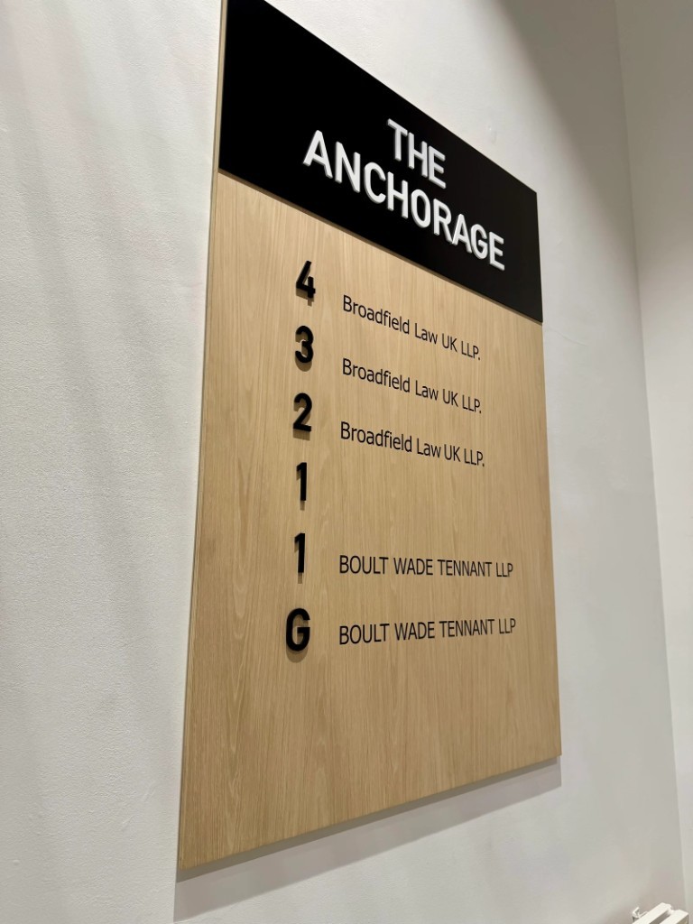 The Anchorage wood-panel directory with floor-by-floor tenant listings