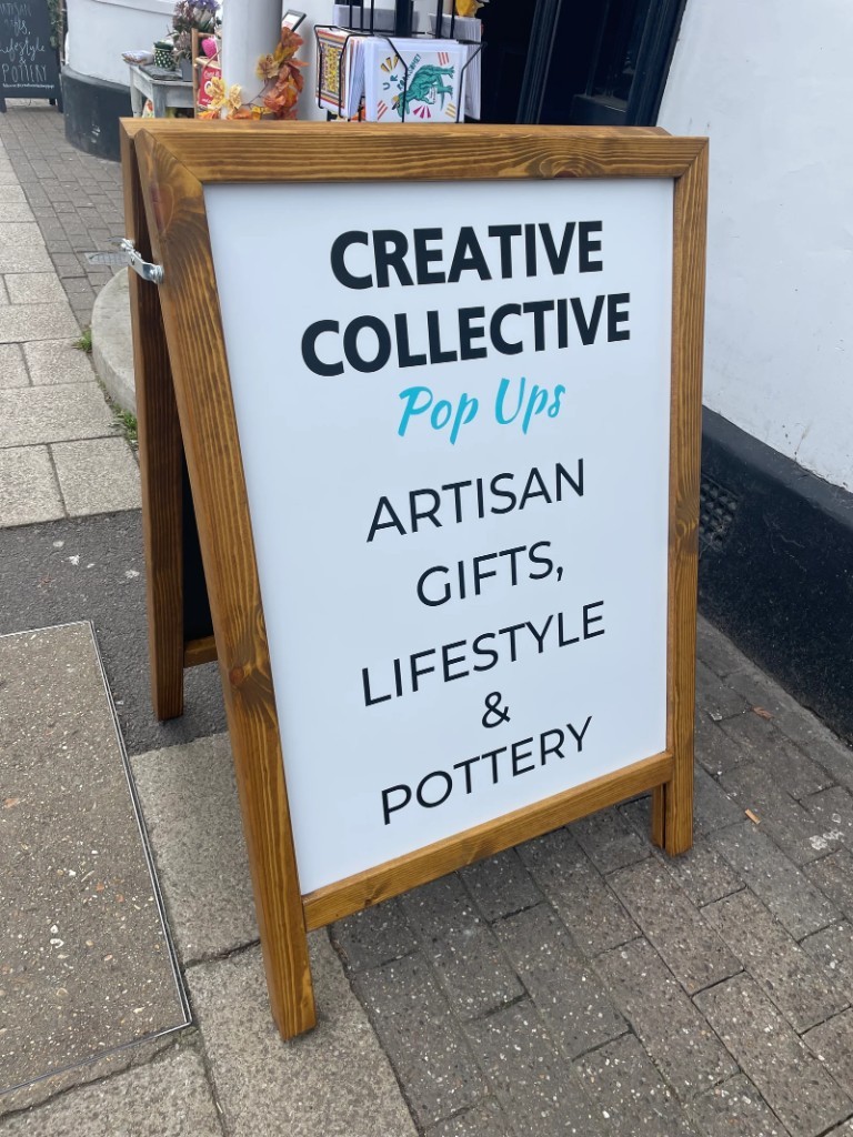 Creative Collective Pop Ups wooden A-board on a shopfront pavement