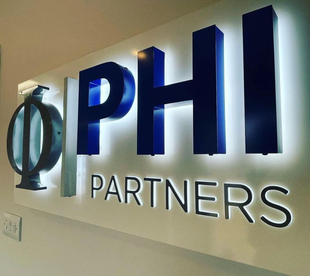 Halo-lit PHI Partners reception sign with back-lit dimensional letters