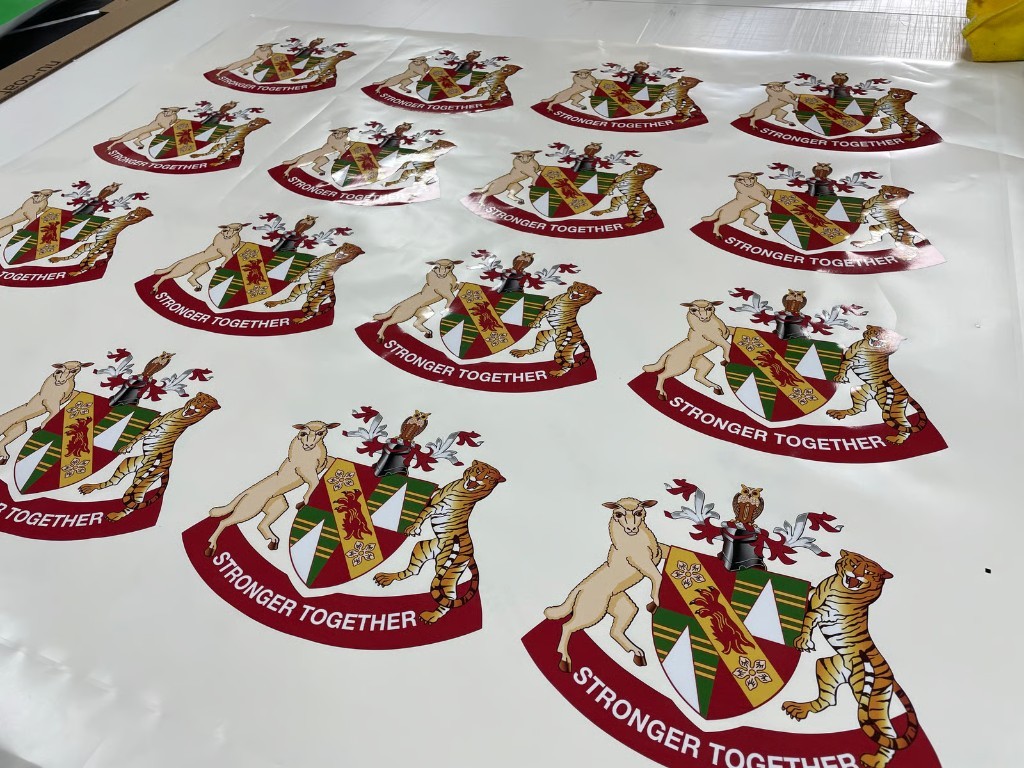 Sheet of Stronger Together crest stickers printed and cut for peel-and-apply use