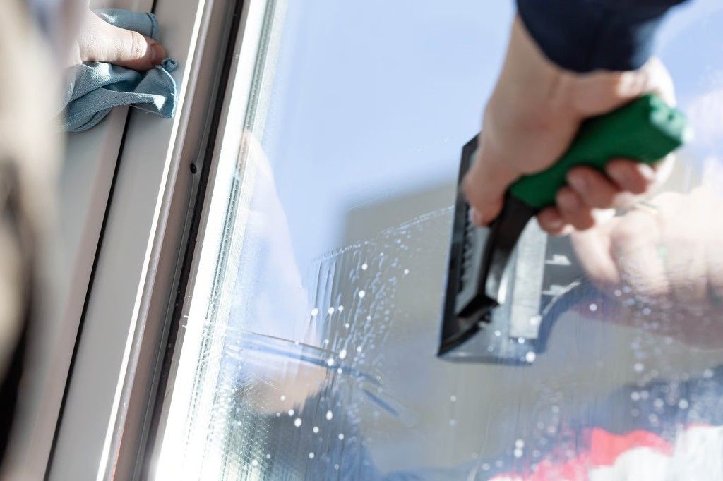 Window film being squeegeed onto glass during installation